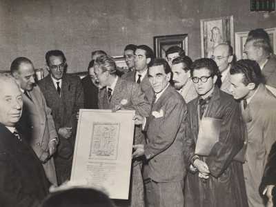 Questa si tenne nella Galleria Niccol� Piccinni, situata nell�omonimo teatro barese e vide la presenza di noti artisti locali tra cui Antonio Lanave, Guido Prayer (che in foto regge il quadro), Gennaro Picinni, Marino Cives